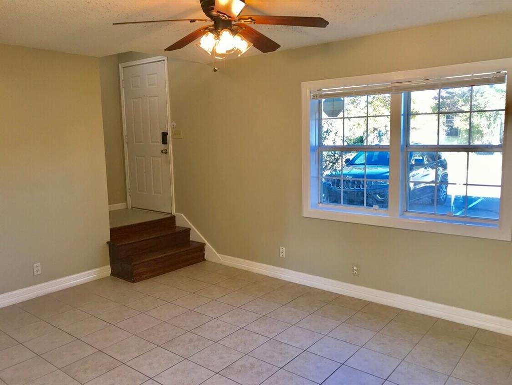 210 Austin Street Grapevine, TX 76051 - Photo 2 of 9 an empty room with windows and ceiling fan