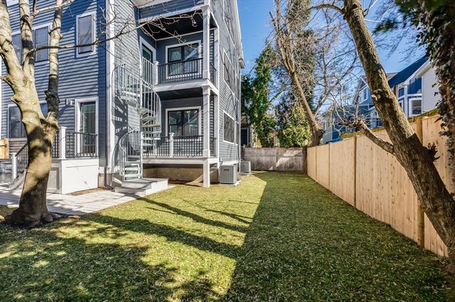 a view of a house with backyard and tree