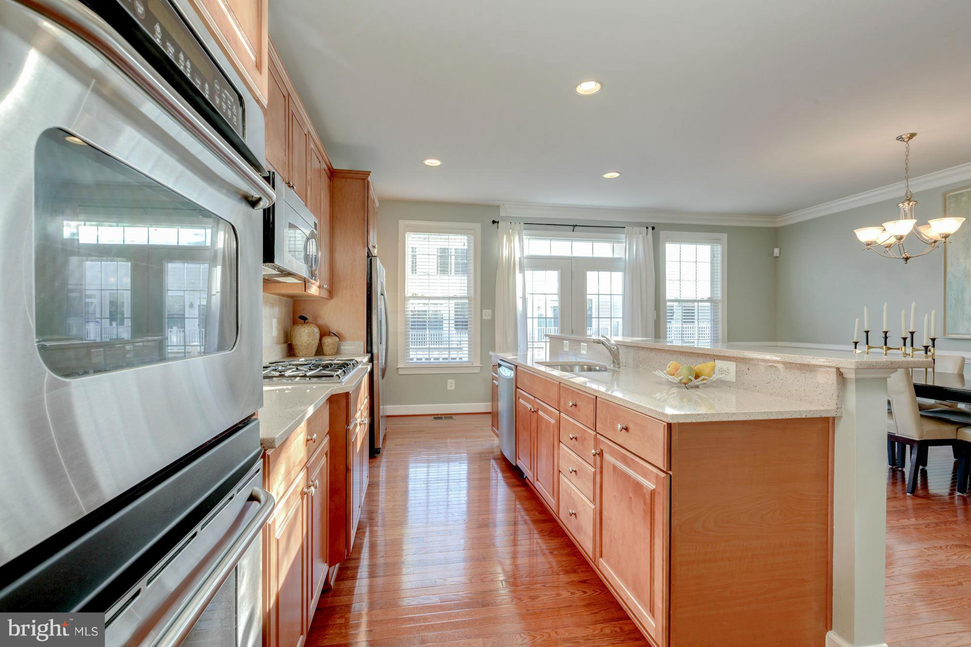 397 Spring Street Herndon, VA 20170 - Photo 12 of 30 a large kitchen with a large counter top space a sink and stainless steel appliances