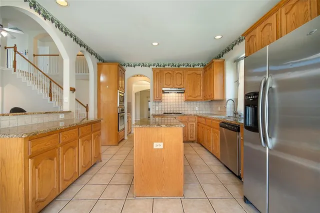 a large kitchen with kitchen island granite countertop a large window and a sink