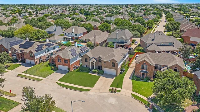 an aerial view of residential houses with outdoor space and parking
