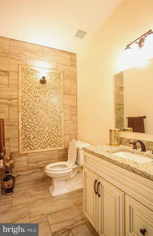 a bathroom with a granite countertop sink a toilet and a shower