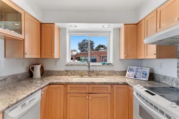 a kitchen with stainless steel appliances granite countertop a sink stove and cabinets