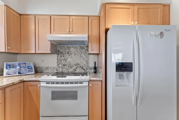 a kitchen with a refrigerator and a stove