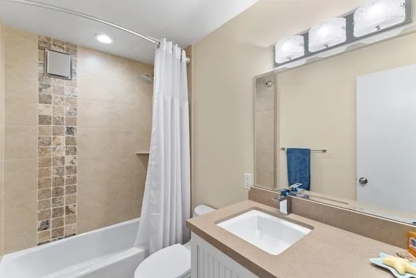 a bathroom with a sink toilet tub and shower