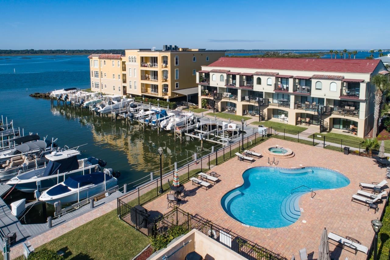aerial view of a house with swimming pool outdoor seating and lake view