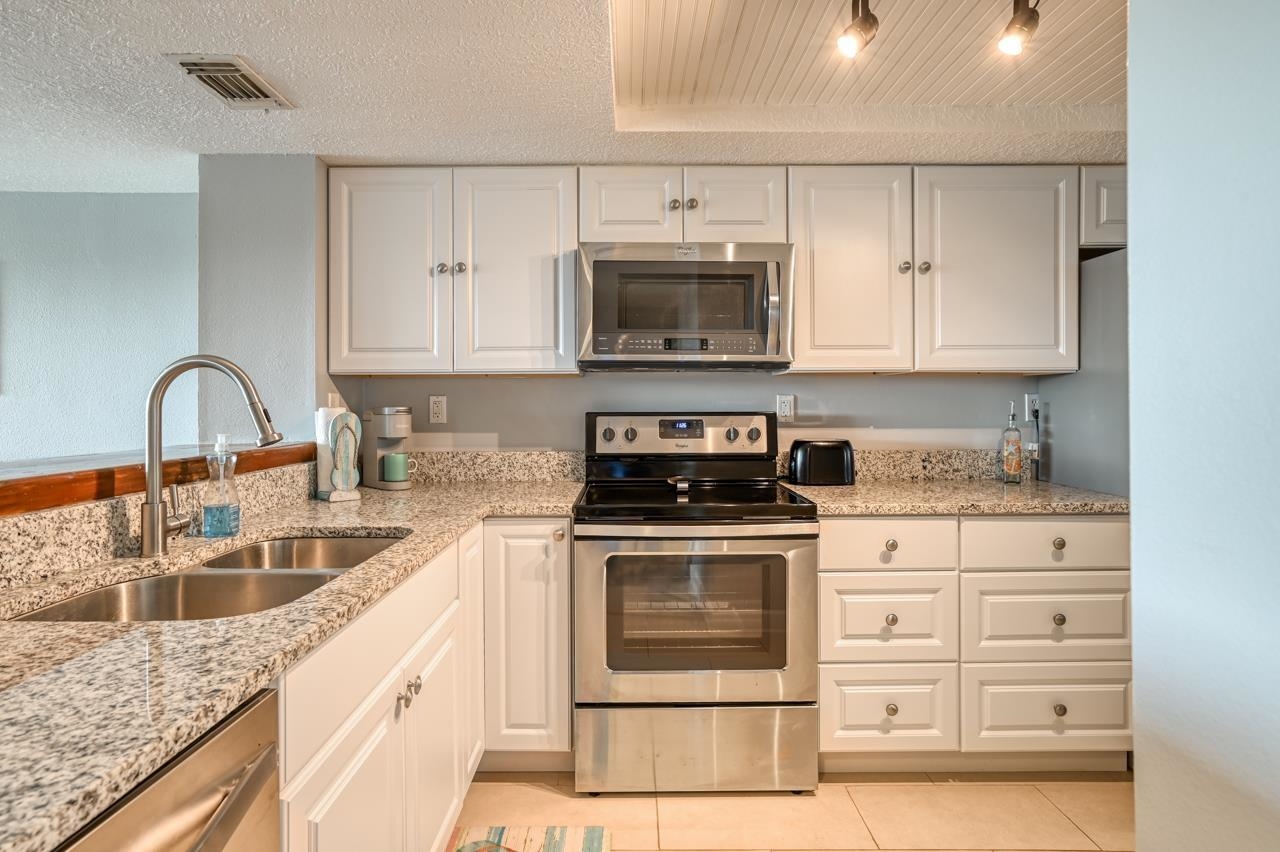 120 Sunset Harbor Way, Unit 204 St. Augustine, FL 32080 - Photo 12 of 49 a kitchen with granite countertop a sink stove and cabinets