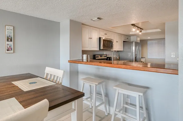 a kitchen with stainless steel appliances kitchen island granite countertop a sink a stove counter space and furniture