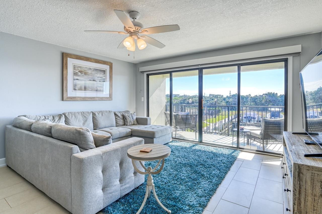 120 Sunset Harbor Way, Unit 204 St. Augustine, FL 32080 - Photo 21 of 49 a living room with furniture and a large window with balcony view