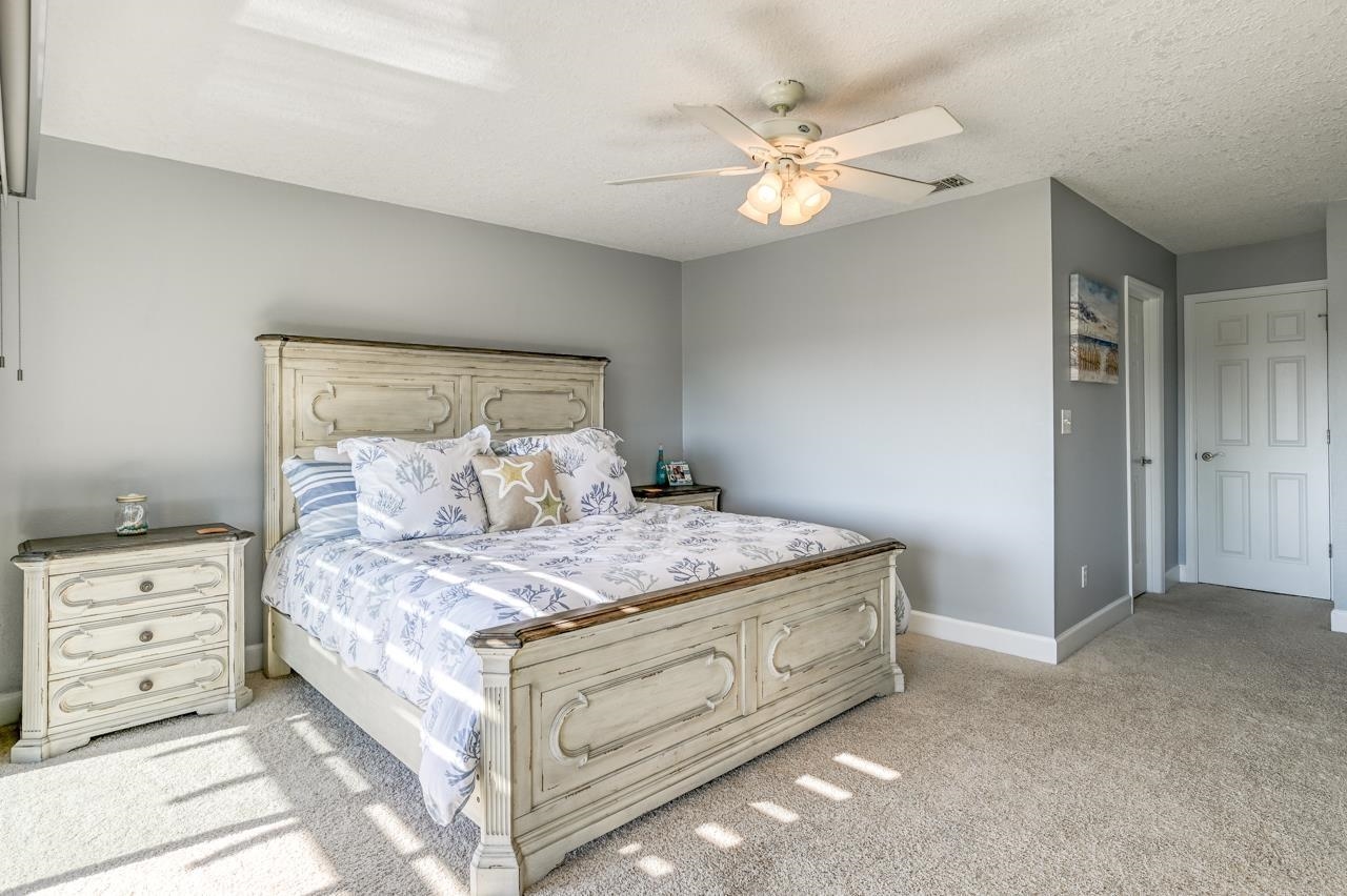 120 Sunset Harbor Way, Unit 204 St. Augustine, FL 32080 - Photo 34 of 49 a bedroom with a large bed and chandelier