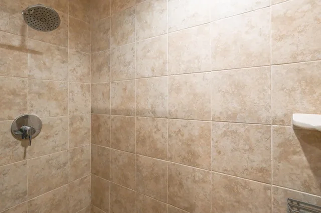 a spacious bedroom with a bed and a chandelier