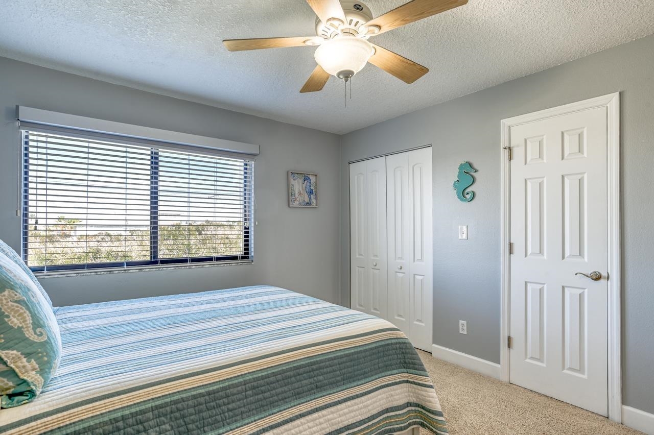 120 Sunset Harbor Way, Unit 204 St. Augustine, FL 32080 - Photo 38 of 49 a spacious bedroom with a bed and a chandelier