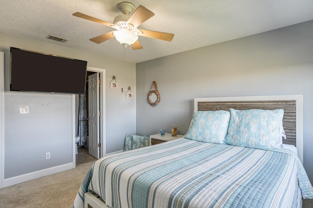 120 Sunset Harbor Way, Unit 204 St. Augustine, FL 32080 - Photo 40 of 49 a bedroom with a large bed and a chandelier