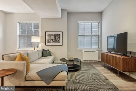 a living room with furniture a flat screen tv and a window