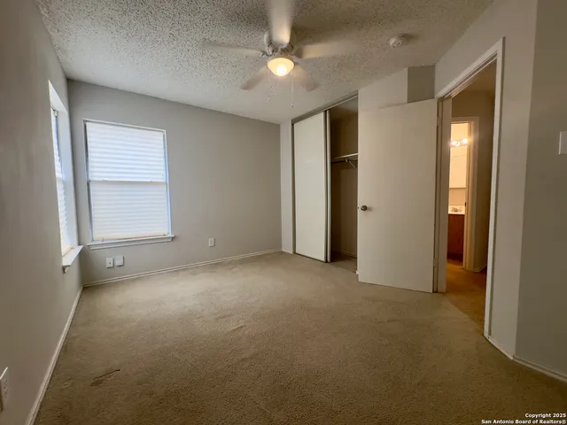 an empty room with fan and windows