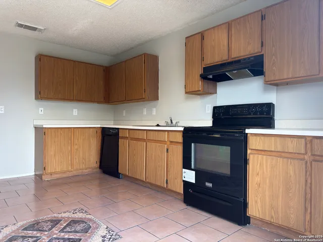a kitchen with a sink cabinets and a window
