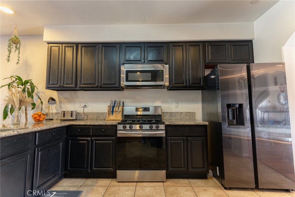 14176 Kiowa Road Apple Valley, CA 92307 - Photo 25 of 54 a kitchen with granite countertop stainless steel appliances and wooden cabinets