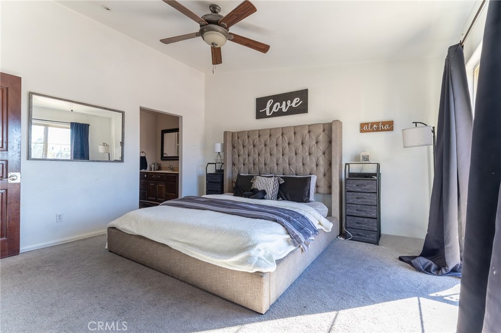 14176 Kiowa Road Apple Valley, CA 92307 - Photo 37 of 54 a bedroom with a bed and a chandelier