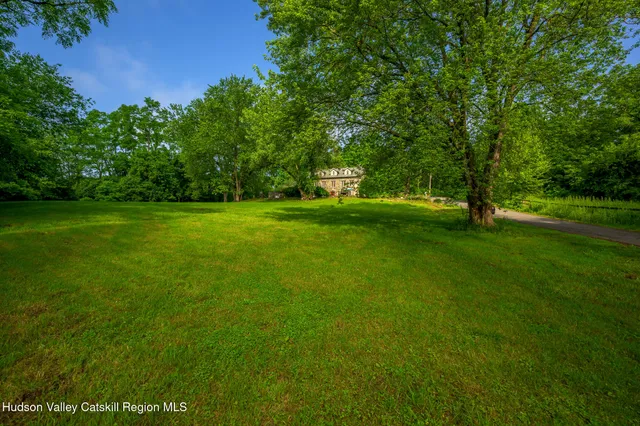 an aerial view of a house around side of green field