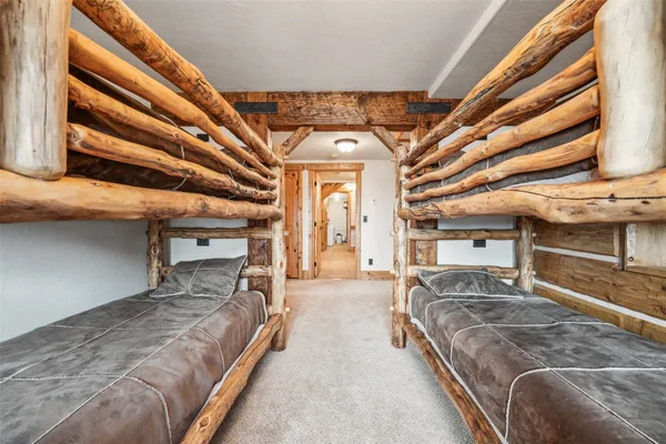 a spacious bedroom with a bed a mirror and furniture
