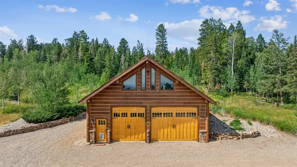 an aerial view of a house with swimming pool and trees