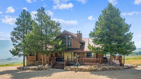 a front view of a house with a tree