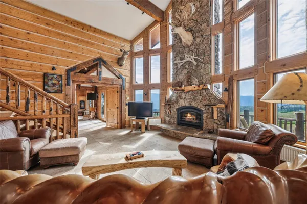 a living room with furniture a fireplace and a large window