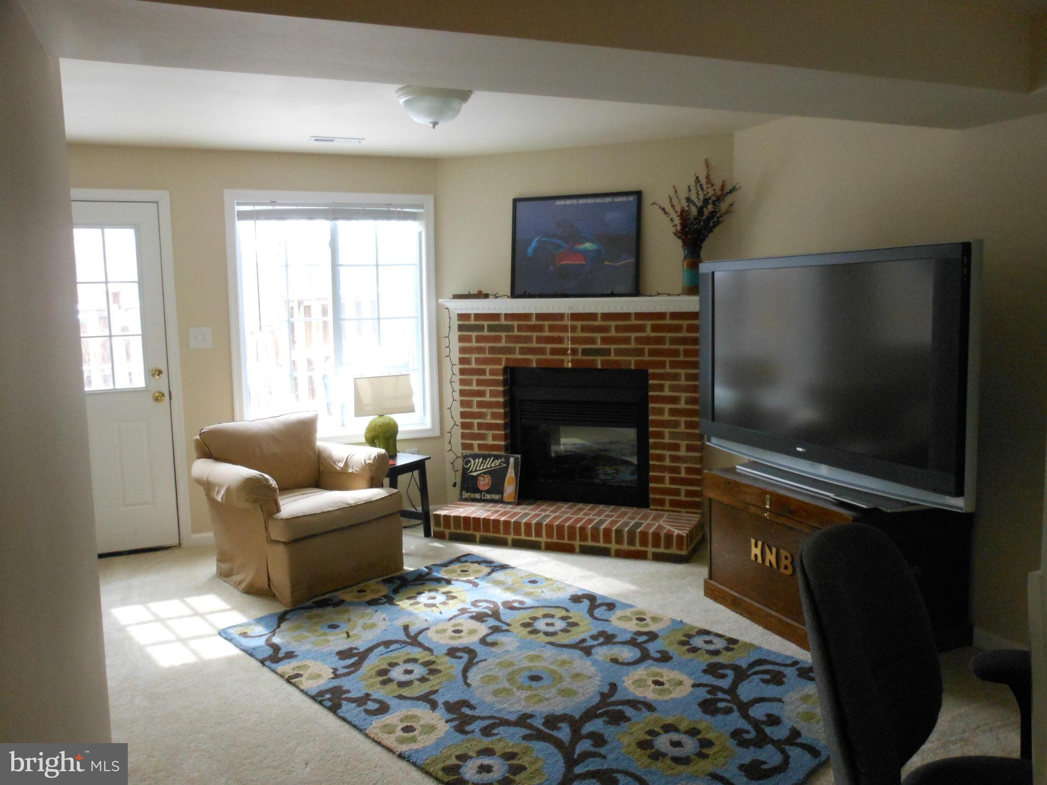 8503 Golden Ridge Court Lorton, VA 22079 - Photo 21 of 27 a living room with furniture a flat screen tv and a fireplace