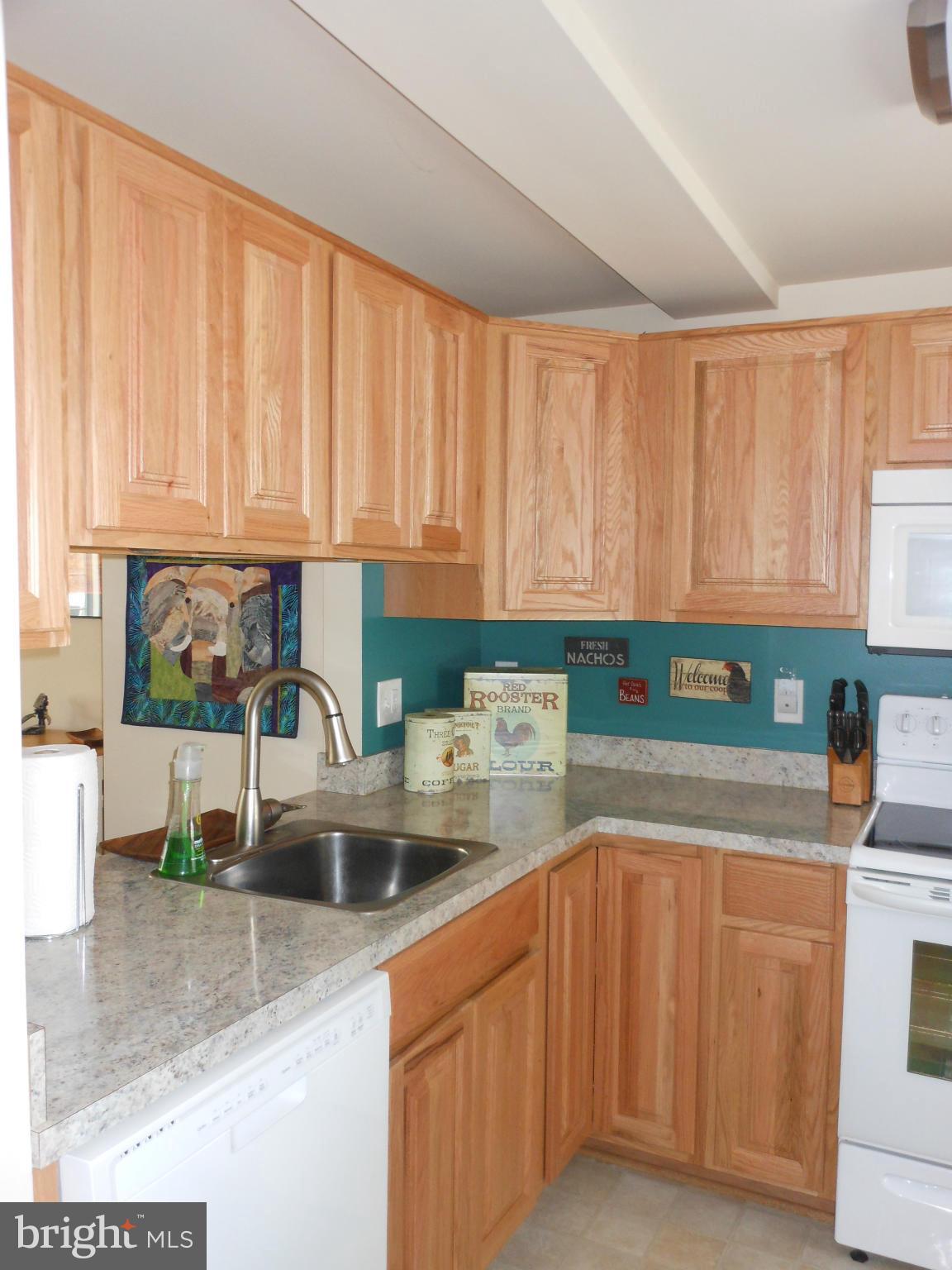 8503 Golden Ridge Court Lorton, VA 22079 - Photo 9 of 27 a kitchen with stainless steel appliances wooden cabinets a sink and a counter top space