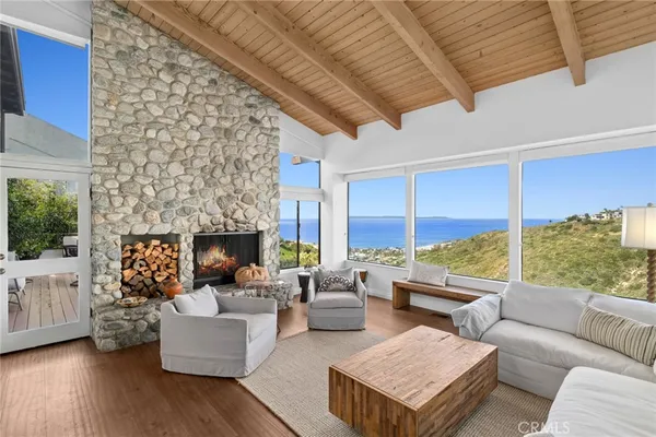 a living room with furniture large windows and a fireplace