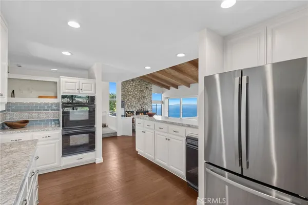 a kitchen with stainless steel appliances a refrigerator and a stove top oven