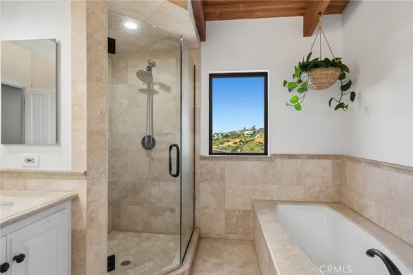 a bathroom with a tub shower and mirror