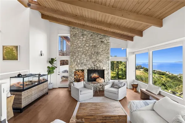 a living room with furniture fireplace and a large window