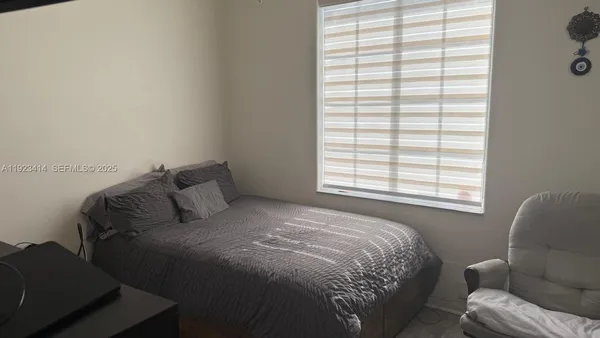 a bed sitting in a bedroom next to a window