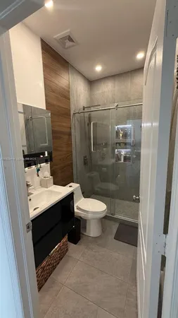 a bathroom with a sink toilet a mirror and shower