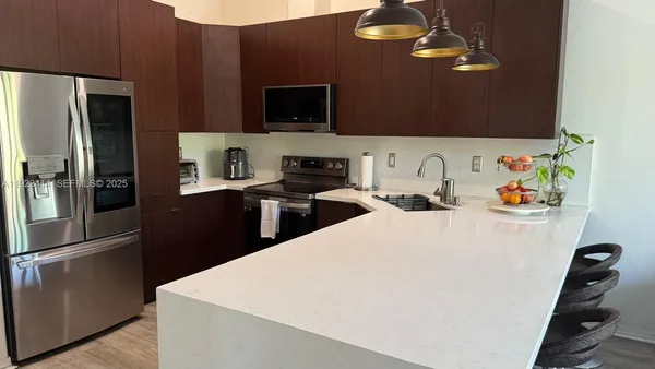 a kitchen with stainless steel appliances a microwave a sink a stove and refrigerator