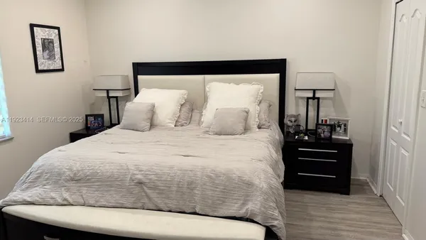 a bedroom with a bed and wooden floor