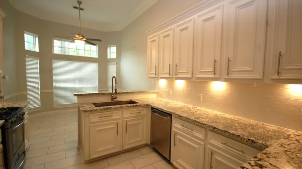 a kitchen with stainless steel appliances granite countertop a stove a sink and a refrigerator