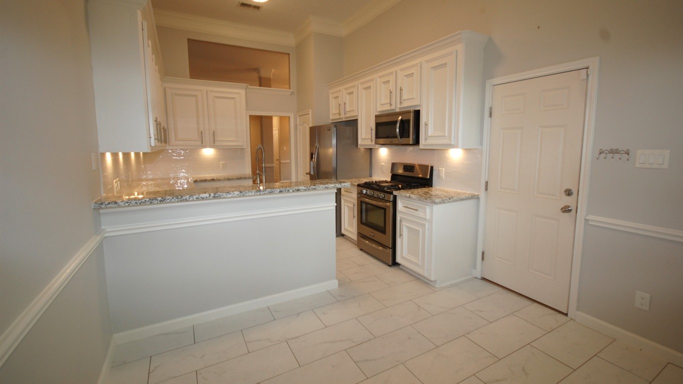 21818 Windsor Castle Drive Spring, TX 77388 - Photo 5 of 10 a kitchen with stainless steel appliances granite countertop a stove a sink and a refrigerator