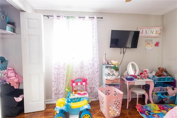 a living room with furniture a flat screen tv and a bed