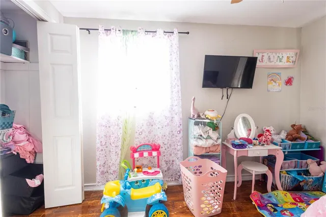 a living room with furniture a flat screen tv and a bed
