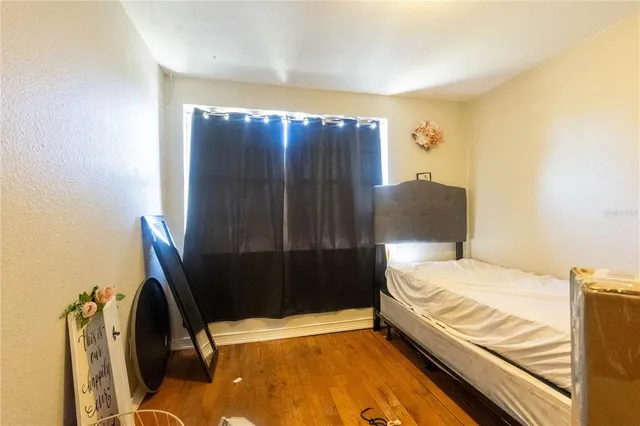 a bedroom with a bed and teddy bear on bed