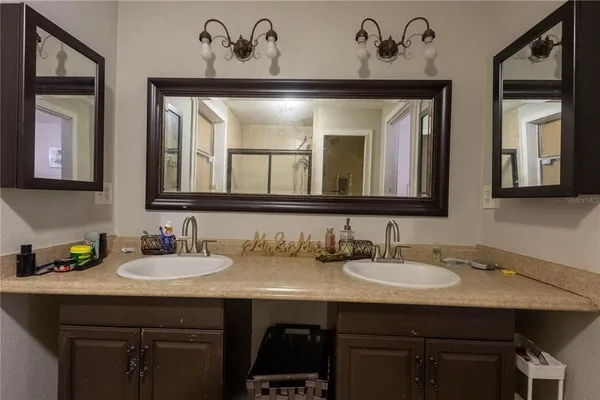 a bathroom with a sink and two mirror