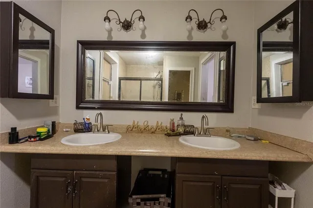 a bathroom with a sink and two mirror
