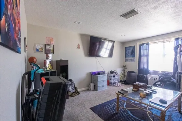 a living room with furniture a flat screen tv and a window