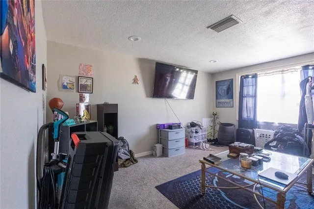a living room with furniture a flat screen tv and a window