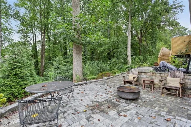 a backyard of a house with fire pit and outdoor seating
