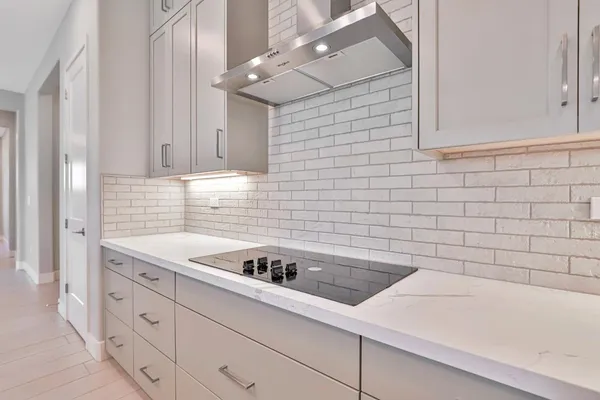 a kitchen with white cabinets and appliances