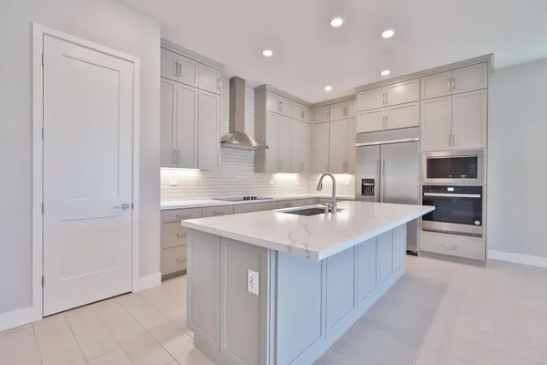 a kitchen with white cabinets and sink