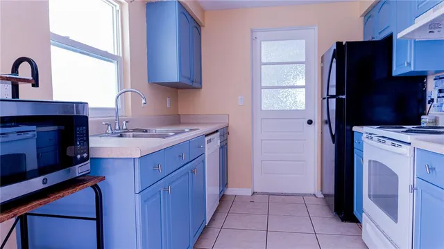 a kitchen with a refrigerator sink and cabinets